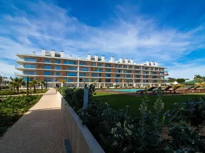 a large building with a pool in front of it at Green 1 Apartment by Stay ici Algarve Holiday Rental in Albufeira