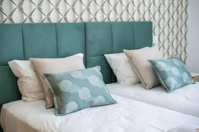two pillows on a bed with a green headboard at Villa Orada 25 by Stay ici Algarve Holiday Rental in Albufeira