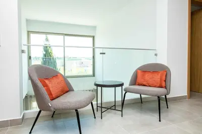 two chairs with orange pillows sitting next to a table at Villa Orada 25 by Stay ici Algarve Holiday Rental in Albufeira