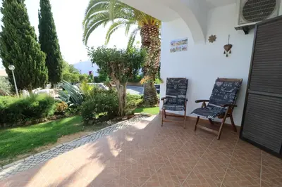 a patio with two chairs and a palm tree at Camelia 52 Beach Studio Apartment - São Rafael, Albufeira in Albufeira
