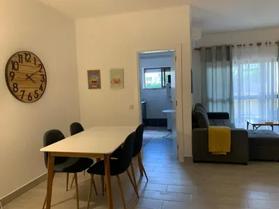 a living room with a table and a clock on the wall at Happydreams apartment in Albufeira in Albufeira