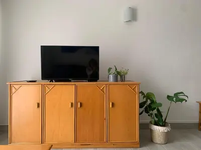 a television sitting on top of a wooden cabinet at Happydreams apartment in Albufeira in Albufeira