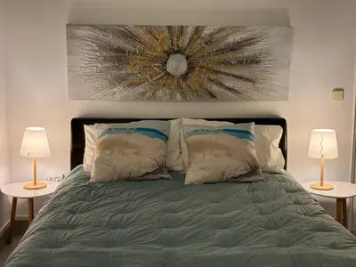 a bedroom with a bed with two lamps and a mirror at Happydreams apartment in Albufeira in Albufeira