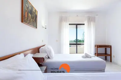 two beds in a hotel room with a window at #132 Velamar 414 by Home Holidays in Albufeira