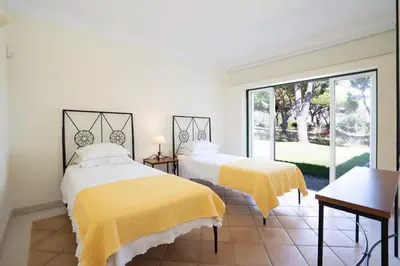 a glass table in a living room with a vase of flowers at Casa Atlantico in Quinta do Lago