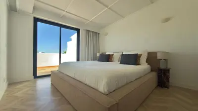 a bedroom with a large bed and a large window at Penthouse S.Jorge Seaview T4 in Quarteira