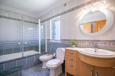 a bathroom with a toilet and a sink and a mirror at Villa Iris in Albufeira