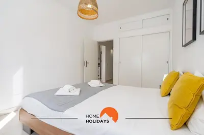 a bed with yellow pillows and a sign that says home holidays at #162 Sumertime Flat by Home Holidays in Albufeira