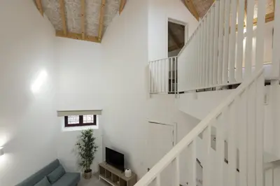 a white staircase with a couch and a television at Madalena Village 3 - City centre by HD PROPERTIES in Faro
