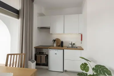 a kitchen with white cabinets and a sink at Madalena Village 1 - City centre by HD PROPERTIES in Faro