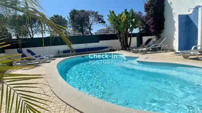 a swimming pool with chairs and a building at Vale Pedras by Check-in Portugal in Albufeira