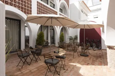 a patio with tables and chairs and umbrellas at Madalena Village 2 - City centre by HD PROPERTIES in Faro