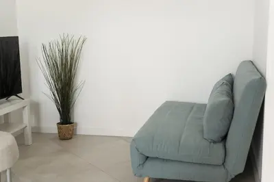 a blue couch in a living room with a plant at Madalena Village 2 - City centre by HD PROPERTIES in Faro