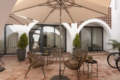 a patio with chairs and an umbrella at Madalena Village 5 - City centre by HD PROPERTIES in Faro