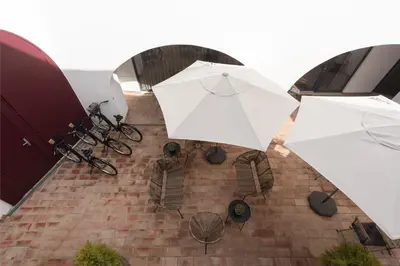 two white umbrellas and chairs on a brick patio at Madalena Village 5 - City centre by HD PROPERTIES in Faro