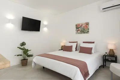 a bedroom with a white bed and a tv on the wall at Madalena Village 5 - City centre by HD PROPERTIES in Faro