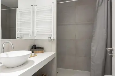 a bathroom with a white sink and a shower at Madalena Village 5 - City centre by HD PROPERTIES in Faro