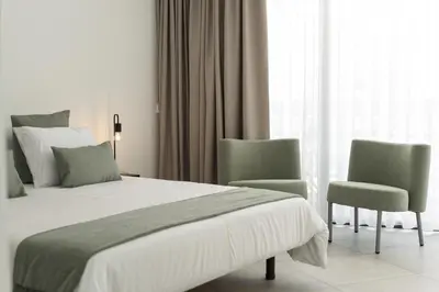 a bedroom with a bed and two chairs at Madalena Village 6 - City centre by HD PROPERTIES in Faro