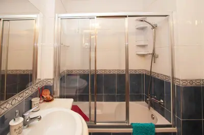 a bathroom with a shower and a sink and a tub at Ondas Verdes by OCvillas in Albufeira