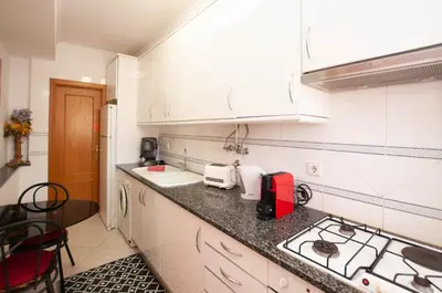a kitchen with white cabinets and a counter top at Ondas Verdes by OCvillas in Albufeira