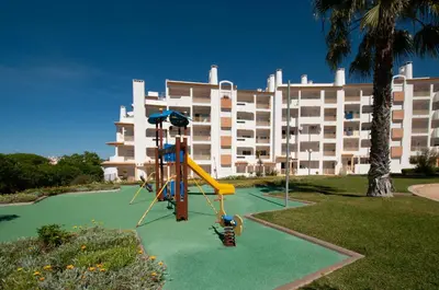 a playground in front of a large building at Ondas Verdes by OCvillas in Albufeira