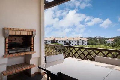 a balcony with a table and a fireplace at Elegance Apartment W/ Balcony & Pool by LovelyStay in Albufeira