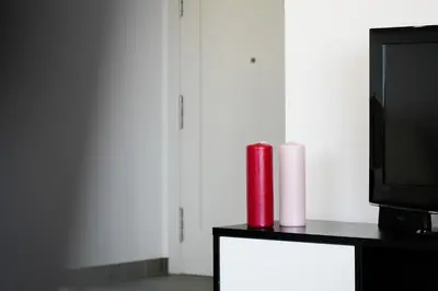 a living room with a tv and a red candle at Elegance Apartment W/ Balcony & Pool by LovelyStay in Albufeira