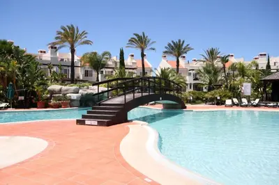 a couch and an umbrella on a patio at 2 bed Apartment Palmyra Vila Sol in Quarteira
