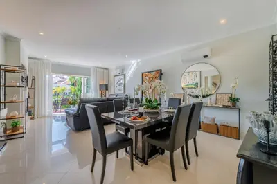 a dining room and living room with a table and chairs at 5 star Luxury Palmview apartment with large terrace and communal pool in Quarteira
