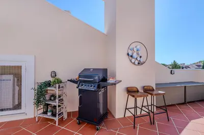 a room with a grill and two stools in it at 5 star Luxury Palmview apartment with large terrace and communal pool in Quarteira