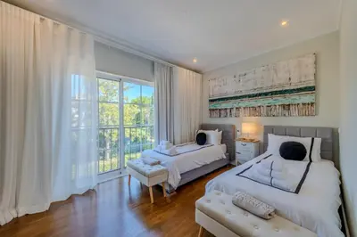 a bedroom with two beds and a large window at 5 star Luxury Palmview apartment with large terrace and communal pool in Quarteira
