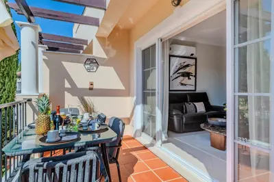 a patio with a table and chairs on a balcony at 5 star Luxury Palmview apartment with large terrace and communal pool in Quarteira
