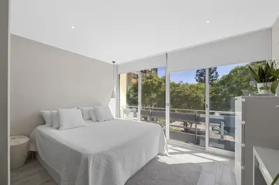 a white bedroom with a bed and a large window at Silver Lux Studio 2 - City Center by HD PROPERTIES in Vilamoura