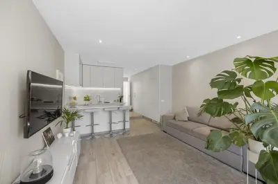 a living room with a couch and a kitchen at Silver Lux Studio 2 - City Center by HD PROPERTIES in Vilamoura