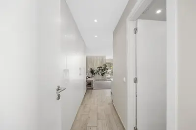 a hallway with white walls and a wooden floor at Silver Lux Studio 2 - City Center by HD PROPERTIES in Vilamoura