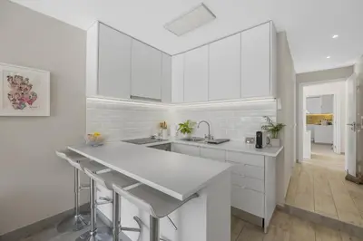 a white kitchen with white cabinets and a sink at Silver Lux Studio 2 - City Center by HD PROPERTIES in Vilamoura