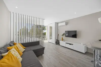 a living room with a couch and a tv at Silver Lux Studio 1 - City Center by HD PROPERTIES in Vilamoura