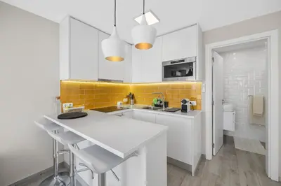 a kitchen with white cabinets and yellow tiles at Silver Lux Studio 1 - City Center by HD PROPERTIES in Vilamoura