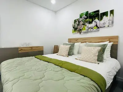 a large bed in a bedroom with two pictures on the wall at Happy Sunrise in Albufeira