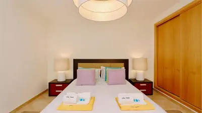 a bedroom with a large white bed with two lamps at Villa Nuki- CleverDetails, quiet location, sleeps 8, private pool in Vilamoura
