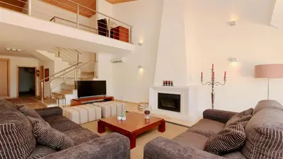 a living room with two couches and a fireplace at Villa Nuki- CleverDetails, quiet location, sleeps 8, private pool in Vilamoura