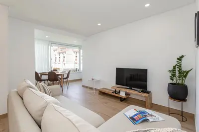 a white living room with a couch and a tv at Centralgarve - Premium Apartment in the Center of Vilamoura - Cota10 in Vilamoura