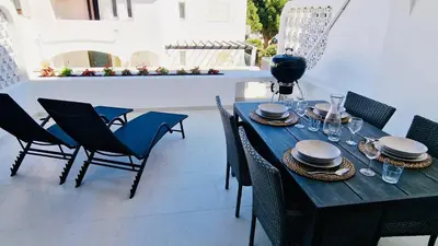 a wooden table with chairs and plates on it at Your dream Getaway Awaits in Vale do Lobo in Almancil