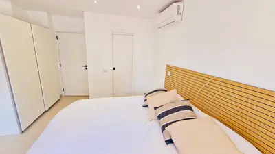 a bedroom with a large bed with a wooden headboard at Your dream Getaway Awaits in Vale do Lobo in Almancil