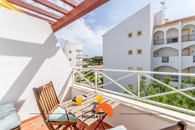 a balcony with a table and chairs and a view of a building at #172 Falésia Beach by Home Holidays in Albufeira