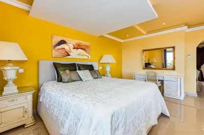 a bedroom with a white bed and a yellow wall at Villa Casa do Monte in Albufeira