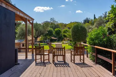a deck with four chairs and a table on it at Villa Algarve 4 Ensuite Bedrooms, Private Swimming Pool, Beautiful Gardens with water features and natural Bio Pool in Almancil
