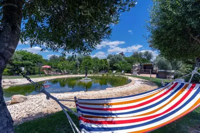 a hammock hanging from a tree in a park at Villa Algarve 4 Ensuite Bedrooms, Private Swimming Pool, Beautiful Gardens with water features and natural Bio Pool in Almancil