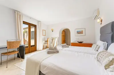 a bedroom with two beds and a desk and a window at Villa Algarve 4 Ensuite Bedrooms, Private Swimming Pool, Beautiful Gardens with water features and natural Bio Pool in Almancil