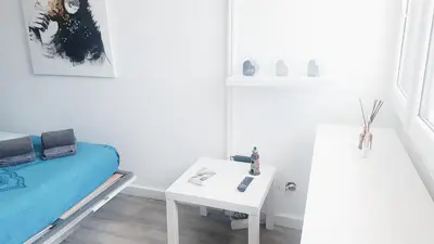 a white room with a bed and a table at Studio Praia de Quarteira in Quarteira